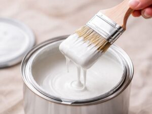 白い塗料を刷毛ですくってる様子