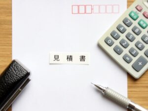 見積書の周りに置かれる電卓、ペン、捺印